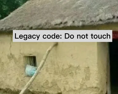 a hut with a thatched roof and a sign that reads 'Legacy code: Do not touch'