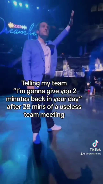 Man in blue suit giving a presentation with a sarcastic comment about a team meeting