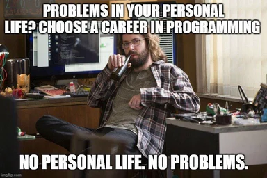 programmer sitting at desk with computer and drinking from bottle