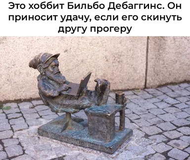 bronze statue of hobbit sitting on chair with laptop