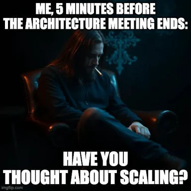 man sitting in a chair with a cigarette, thinking about scaling 5 minutes before architecture meeting ends