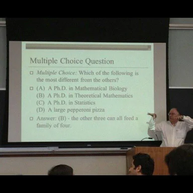 A professor points to a projector screen showing a multiple-choice question comparing PhD degrees to a pepperoni pizza.