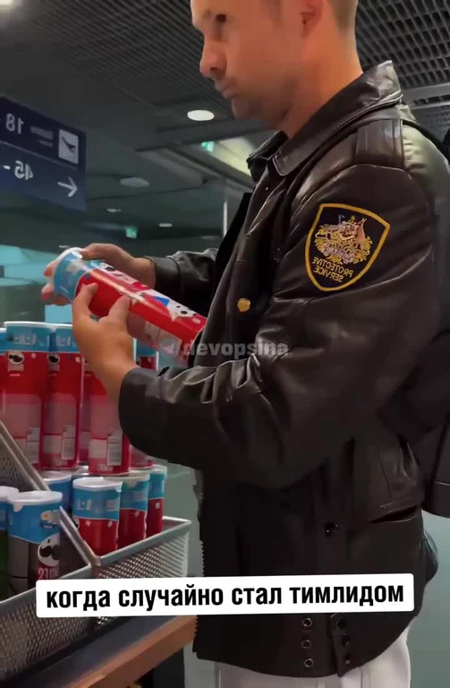 Man in black leather jacket with yellow patch buying energy drinks