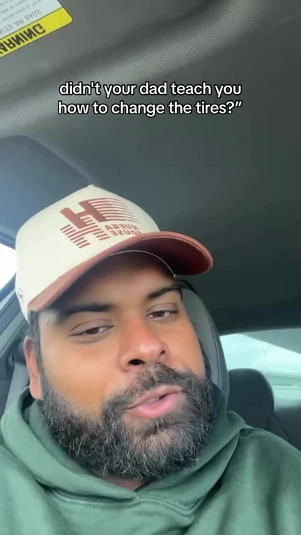 man in green hoodie and beige cap looking unimpressed in a car