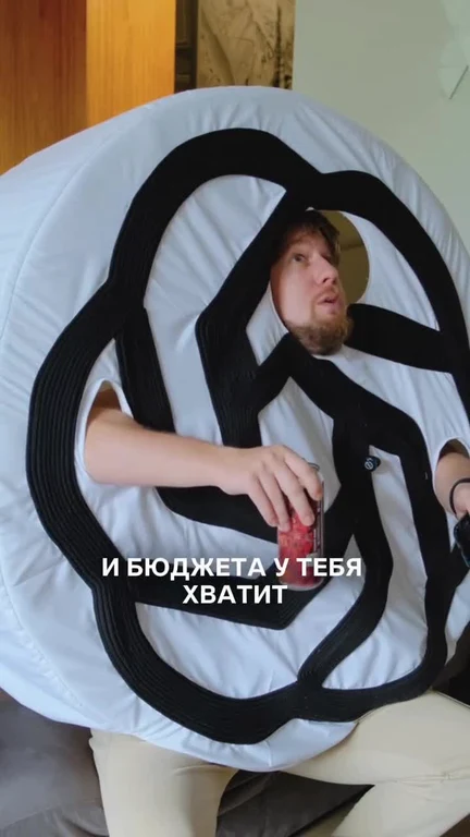 man wrapped in black cables sitting on a large white object