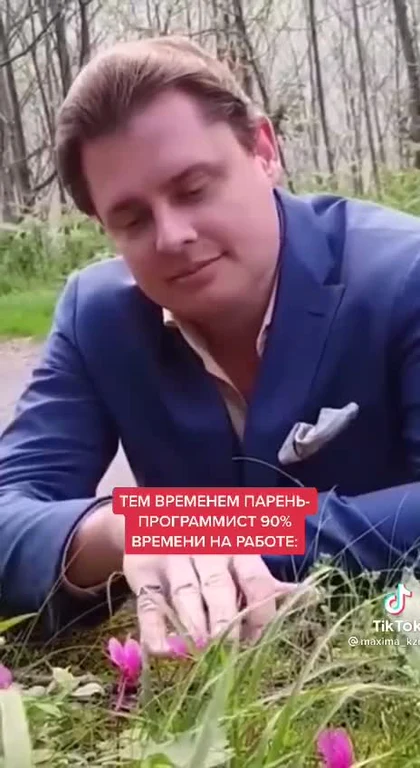 programmer in blue suit touching flowers with russian text overlay