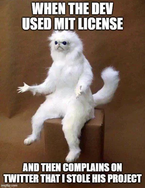 Furry white cat sitting on a box with a caption about MIT license
