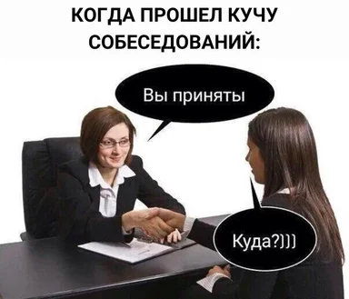 Two women in business attire shaking hands at a desk with a surprised expression
