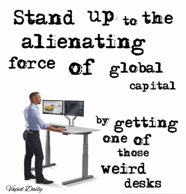 man standing at a sit-stand desk with two monitors