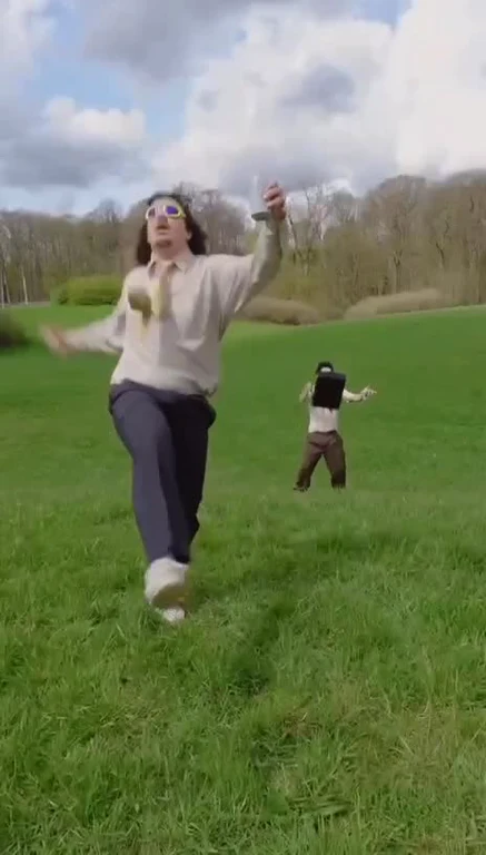 Two people running in a field with a humorous expression