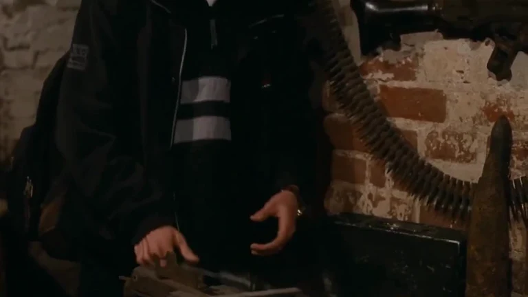 A person in a black jacket loading a large machine gun, used as a metaphor for dealing with legacy code
