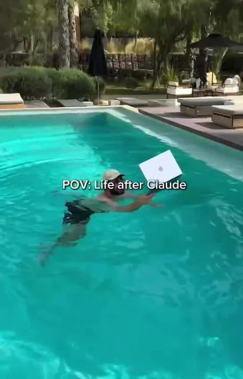 A person swimming in a pool while holding a laptop, with the text overlay 'POV: Life after Claude'.