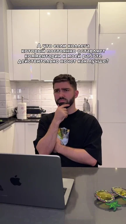 Man sitting at kitchen table with laptop, thinking