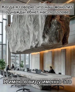 A large rock suspended over a conference table with people sitting at it