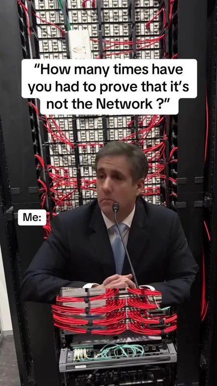 Man in a suit sitting in front of a server with a skeptical expression, implying frustration with network issues.