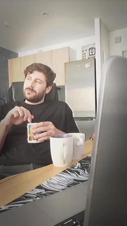 Man sitting at a desk with two coffee mugs