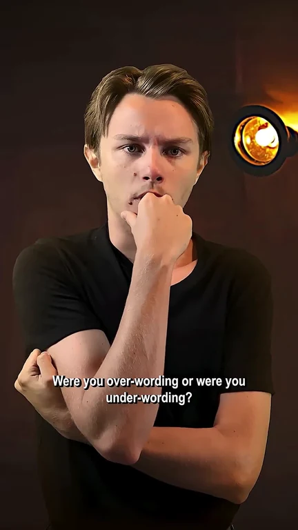 A man in a black t-shirt with a thoughtful expression, text overlay 'Were you over-wording or were you under-wording?'