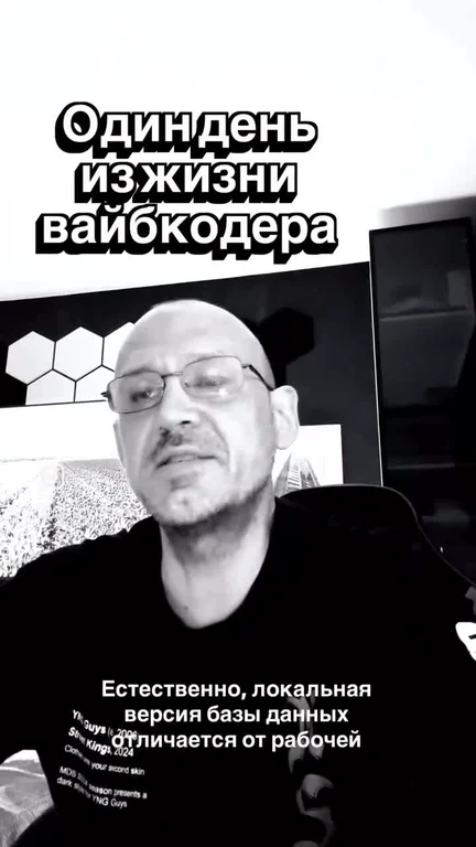 Чёрно-белый кадр: лысый мужчина в очках и чёрной футболке за компьютером с текстом «Один день из жизни вайбкодера» и