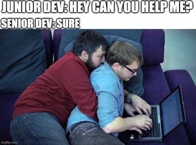 Two developers sitting on a couch, one leaning on the other, looking at a laptop