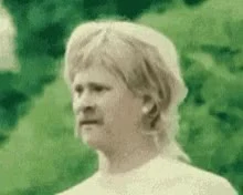 Close-up of a confused man looking sideways with a skeptical expression