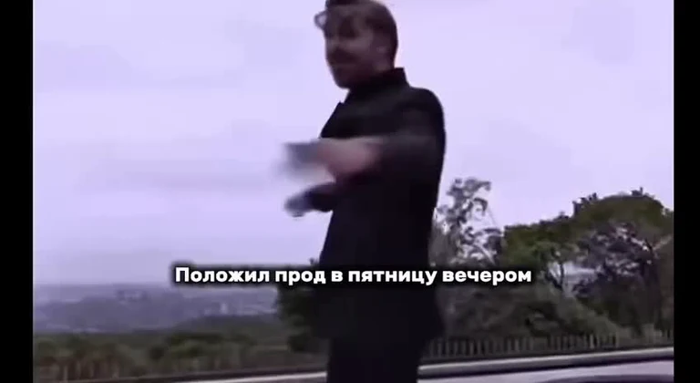Man in black clothes throwing something with a cityscape in the background