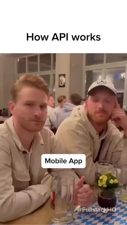 Two men sitting at a table with a confused expression, representing how API works with a mobile app