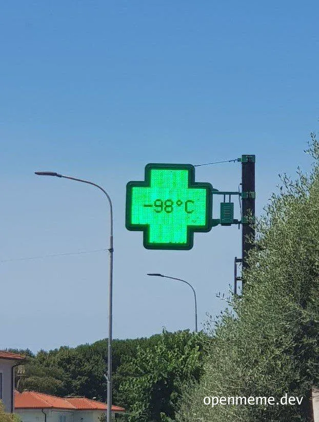 Green digital pharmacy cross sign displaying -98 degrees Celsius against a blue sky