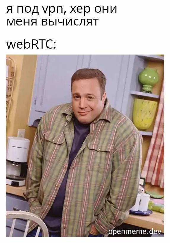 man in plaid shirt smiling smugly in kitchen