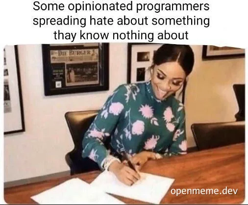 Kim Kardashian sitting at a desk writing on a piece of paper with a caption about programmers spreading hate