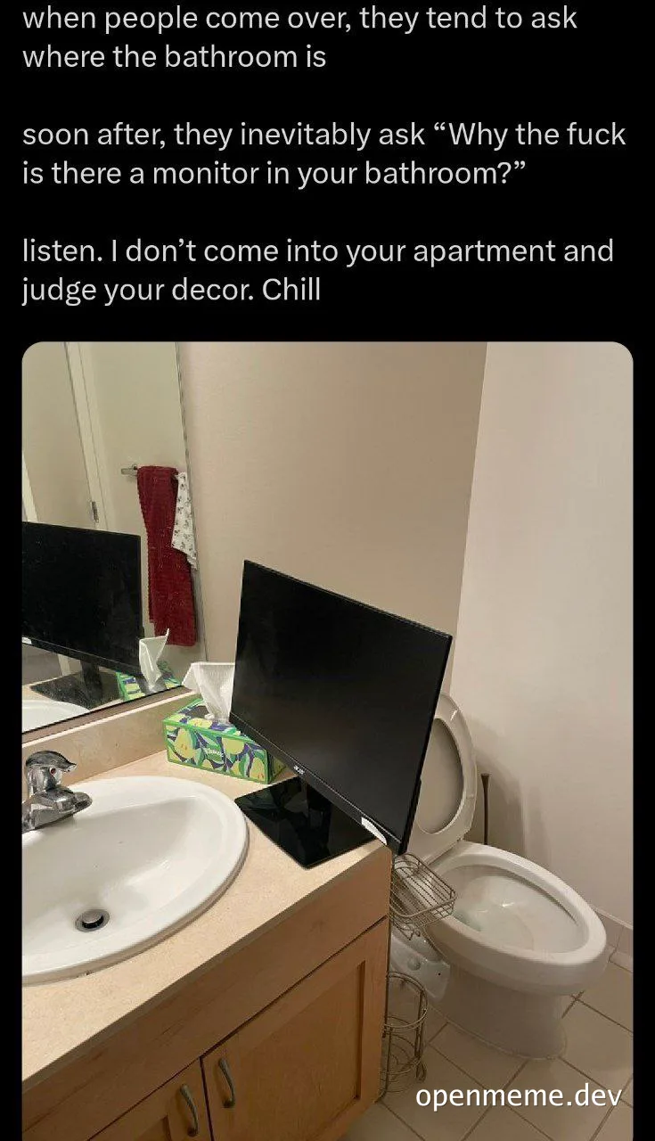 a bathroom with a monitor on the sink