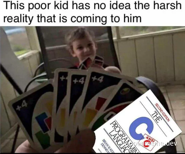 a kid looking at a hand of Uno cards with a C programming language textbook on top