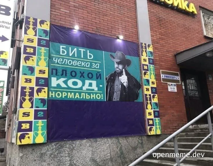 A large poster on a brick building with a man in a cowboy hat and text in Russian