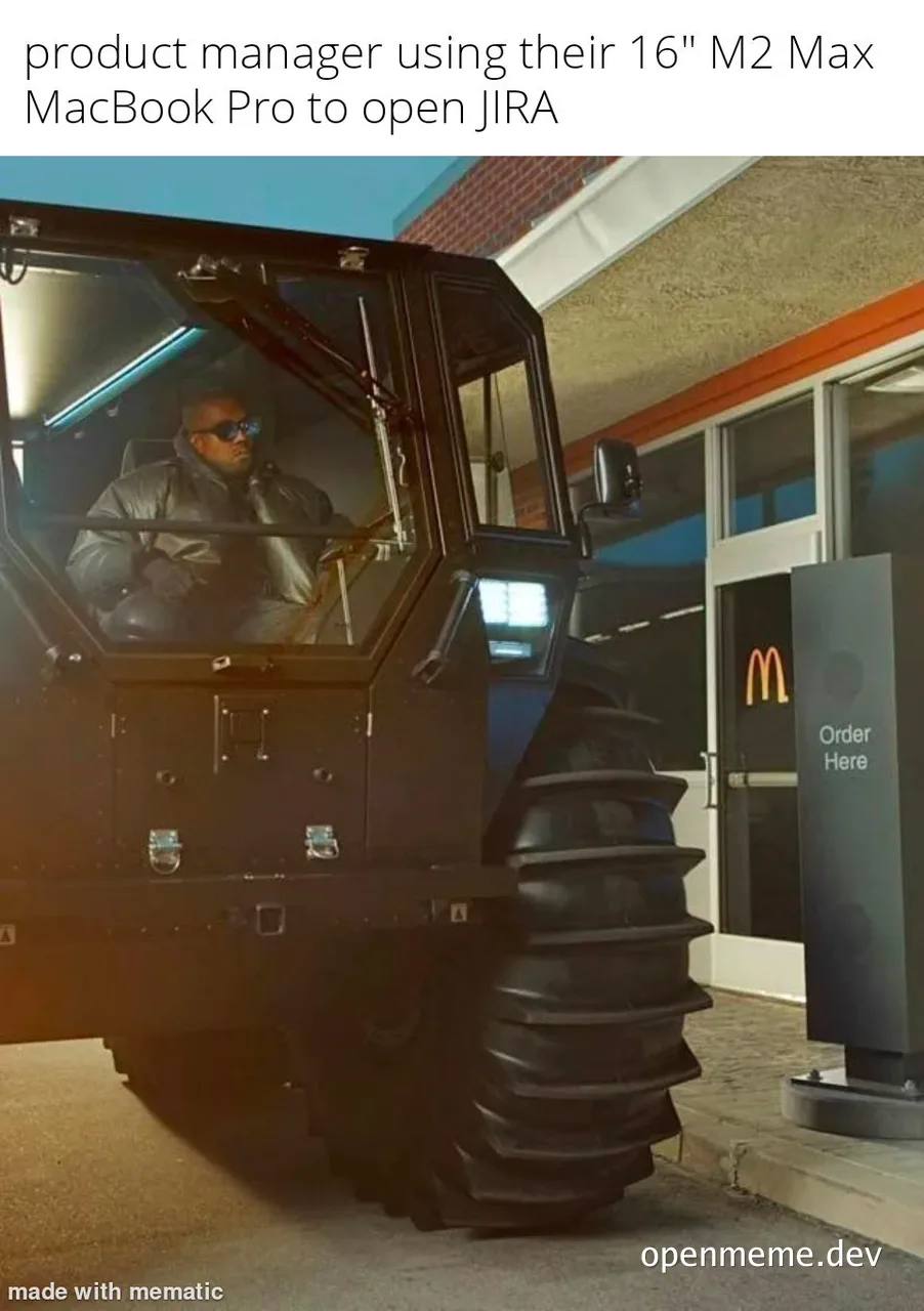 Kanye West in a large vehicle using a MacBook to open JIRA at McDonald's