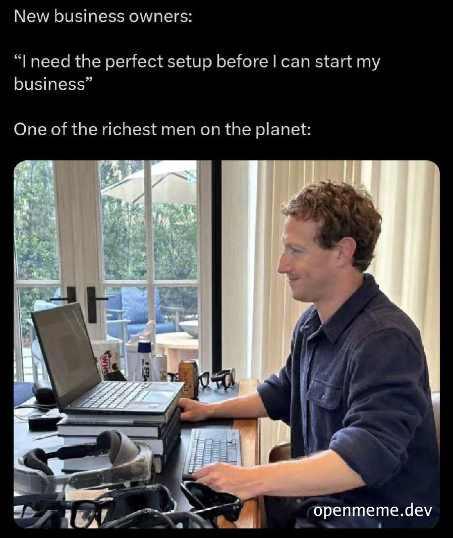 Mark Zuckerberg sitting at a desk with multiple devices