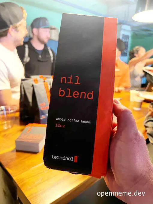A hand holding a bag of coffee beans labeled 'nil blend' with a terminal logo