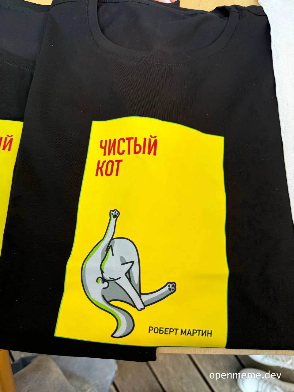 black t-shirt with yellow book cover design featuring a dancing cat and Russian text