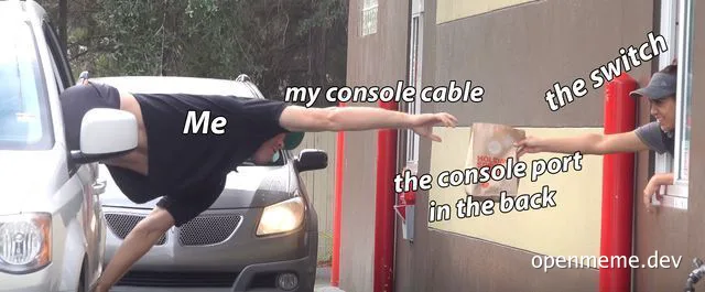 Man stretching to connect console cable to a switch