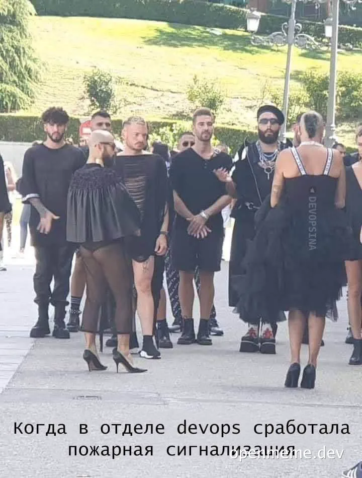 group of people in black clothing standing on sidewalk