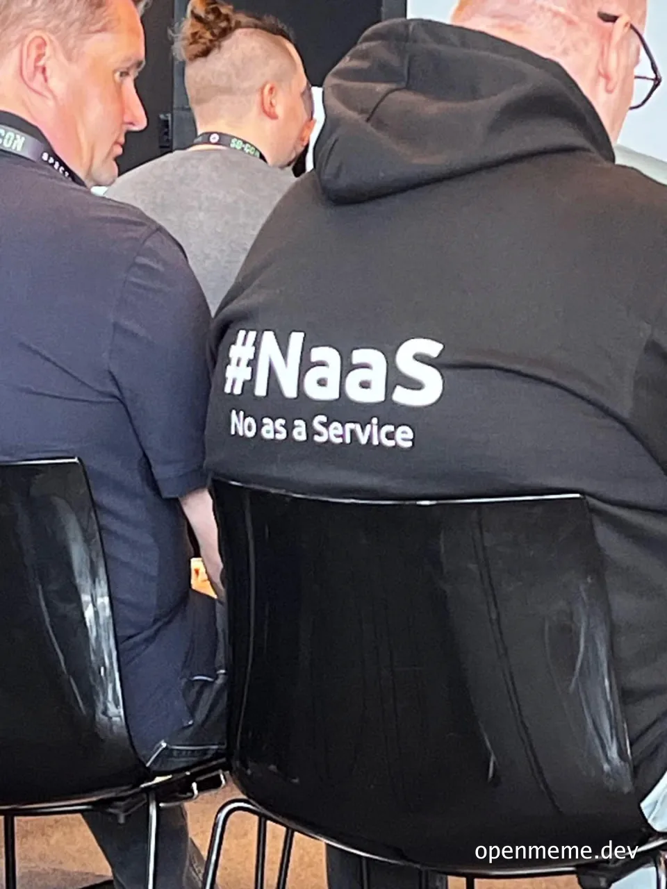 man wearing black hoodie with #Naas No as a Service text