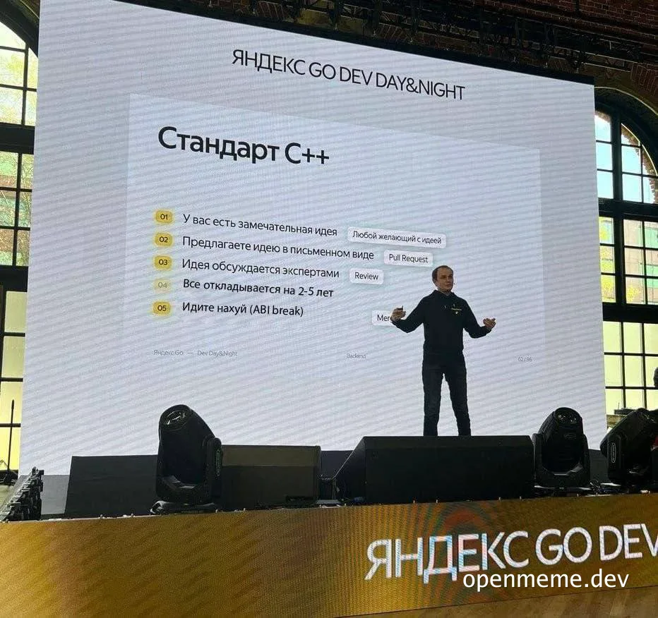 man on stage in front of a projector screen with a humorous list about C++ standards