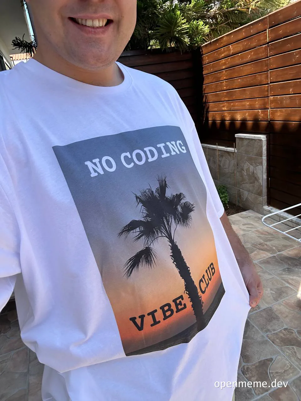 man wearing white t-shirt with 'NO CODING VIBE CLUB' text and palm tree graphic