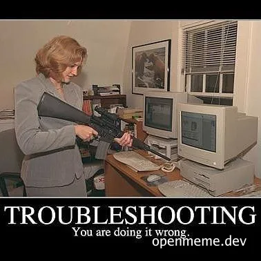 Woman holding a large rifle pointing at computer screens on a desk with text 'TROUBLESHOOTING You are doing it wrong.'