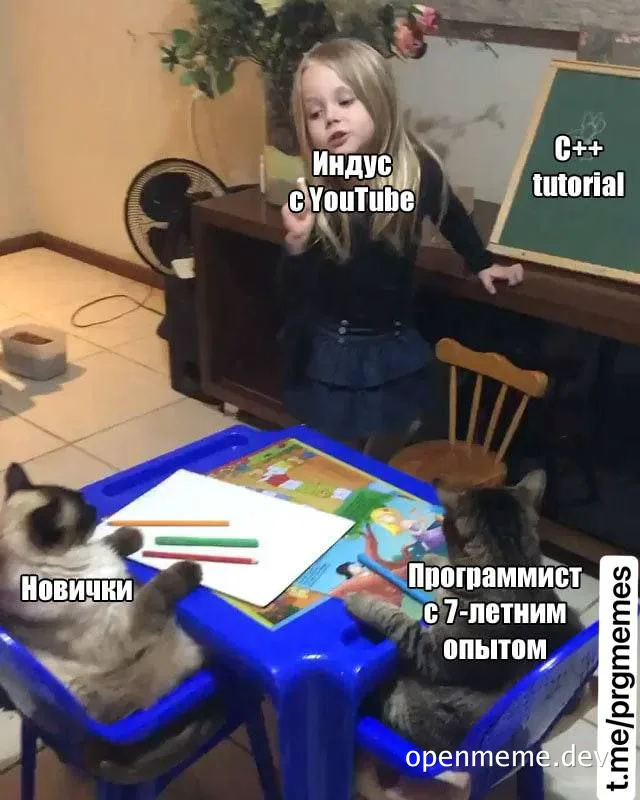 Two cats sitting at a children's table with a girl teaching C++