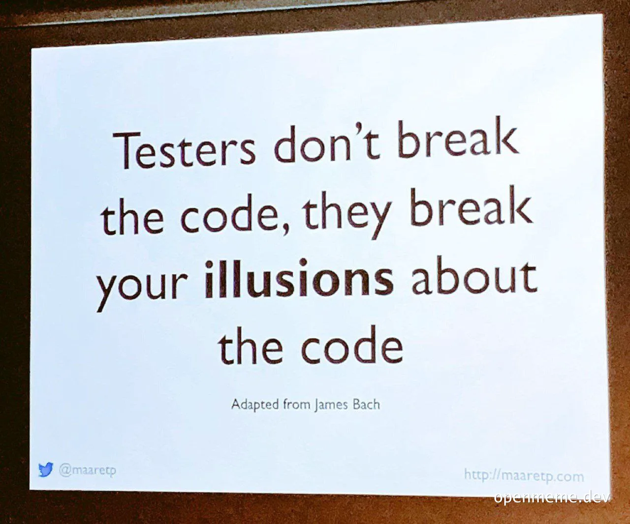 White printed card with the quote: Testers don't break the code, they break your illusions about the code. Adapted from