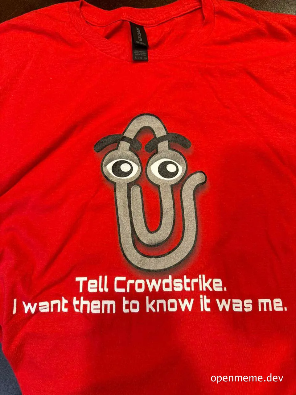 Paperclip with eyes and eyebrows on a red t-shirt with the text 'Tell Crowdstrike. I want them to know it was me.'