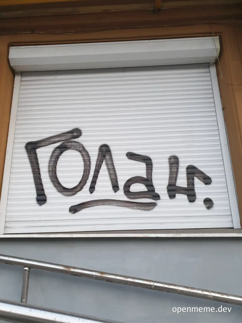 Graffiti on a window with the text 'Цой жив' spray painted