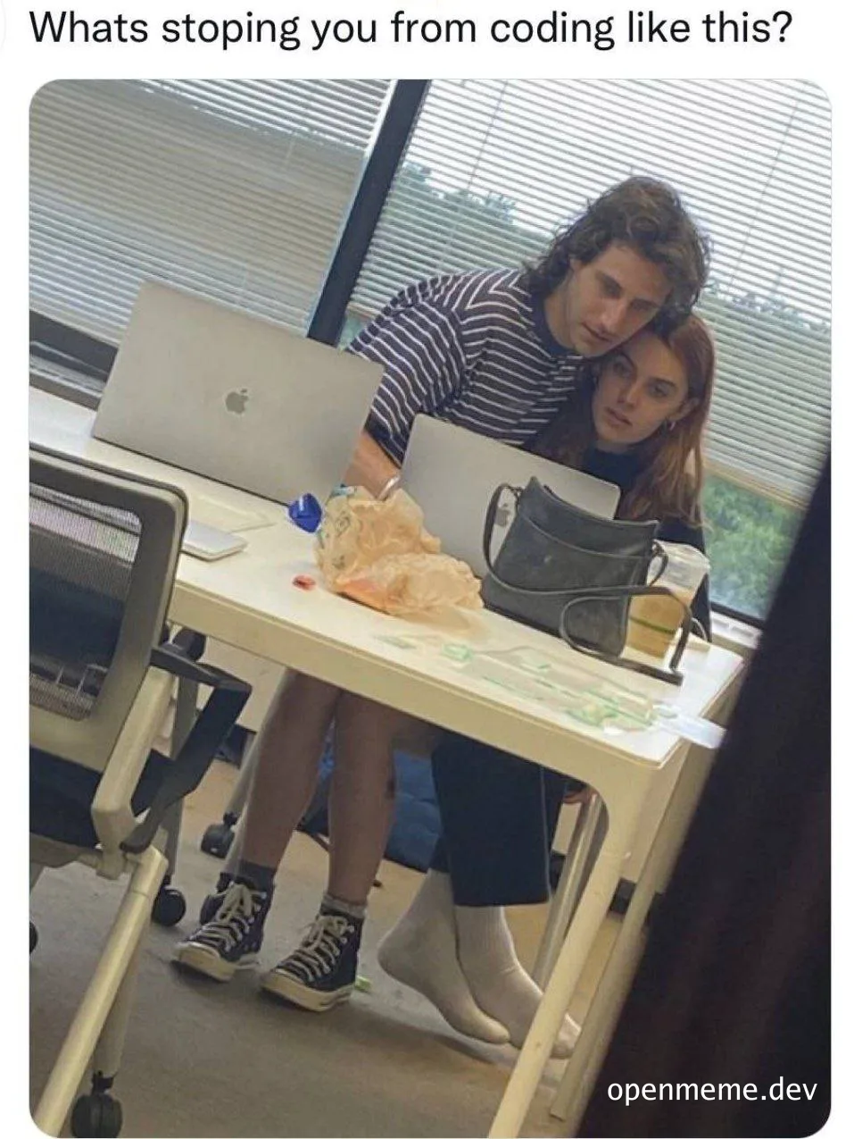 Couple sitting at office desk with laptops