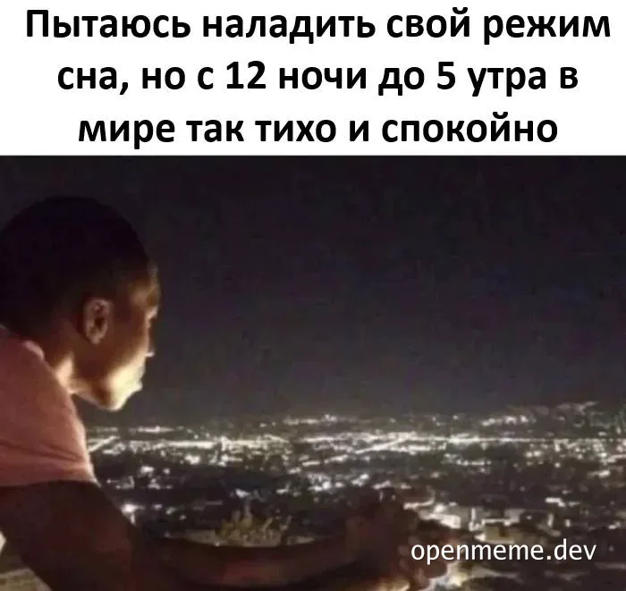 Man looking out over a city at night, contemplating sleep schedule