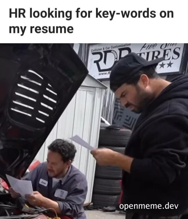 Two mechanics looking at papers in a car engine, representing HR searching for keywords on a resume.