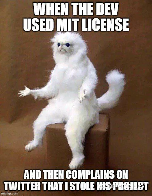 Furry white cat sitting on a box with a caption about MIT license
